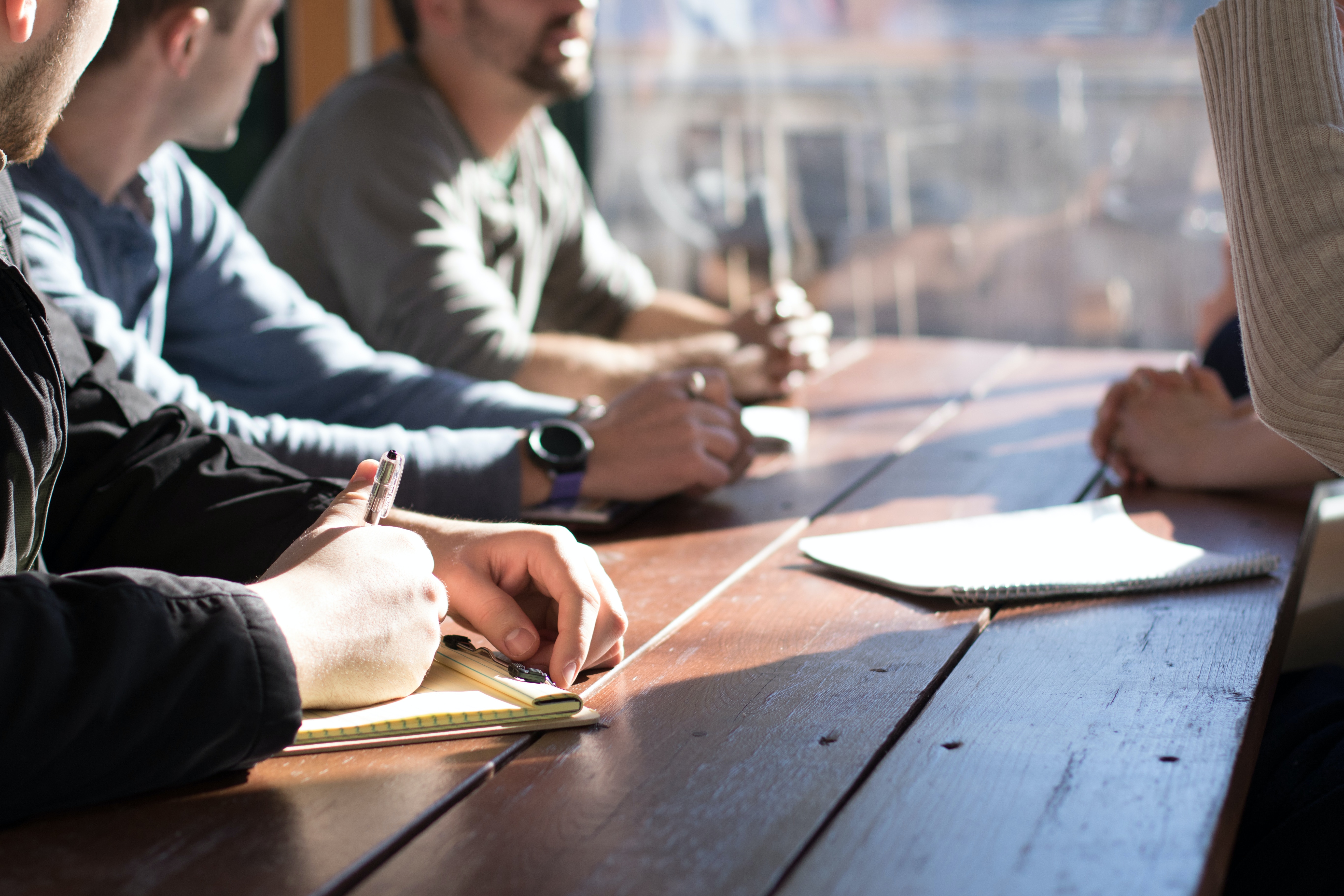 Firm management having a meeting at a wooden table